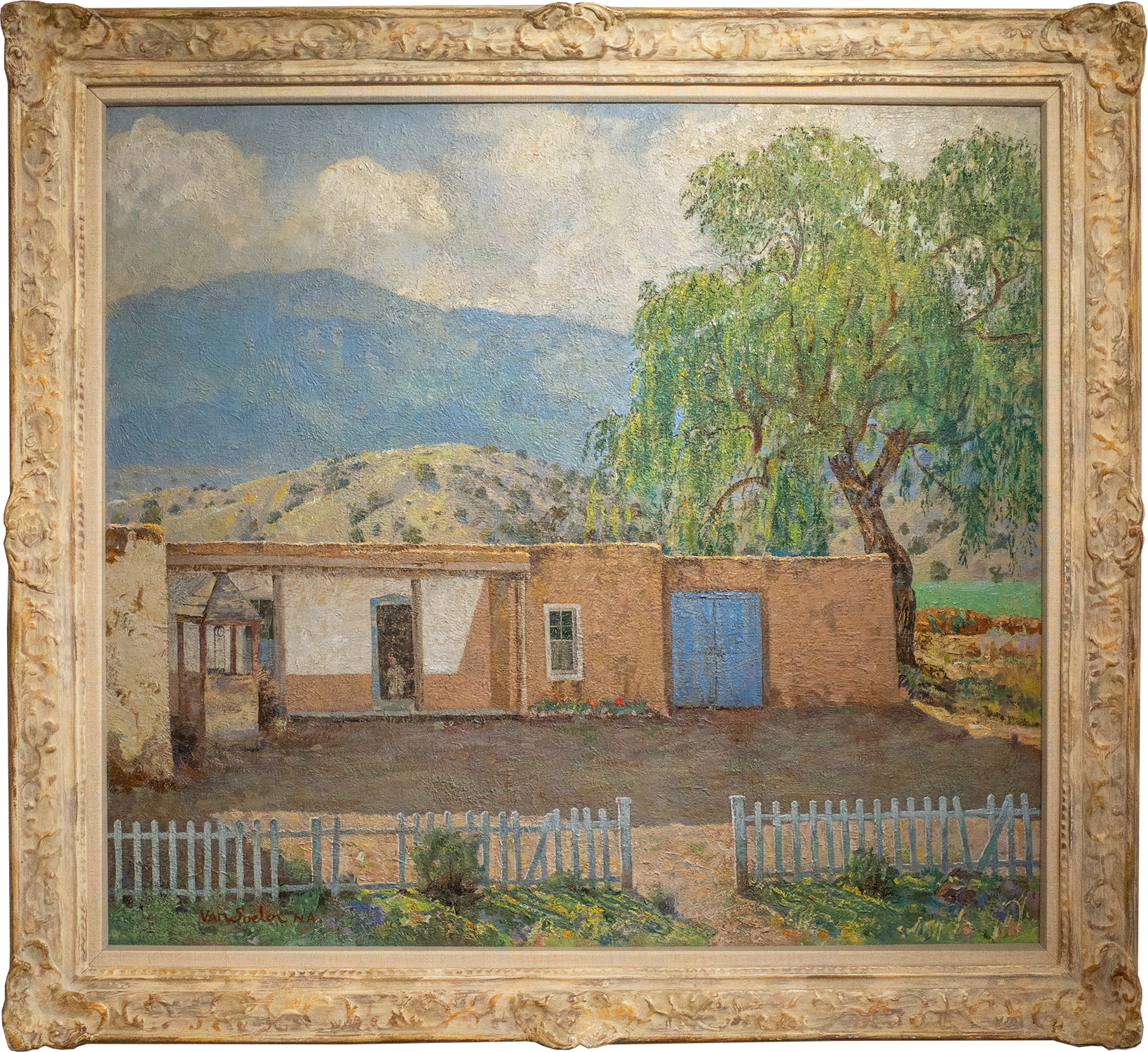 A textured oil painting of an adobe house with a blue door and a large green tree to the side, set against a backdrop of hills under a cloudy sky, encased in an ornate gold frame. Title: Old Las Vegas Highway Home.